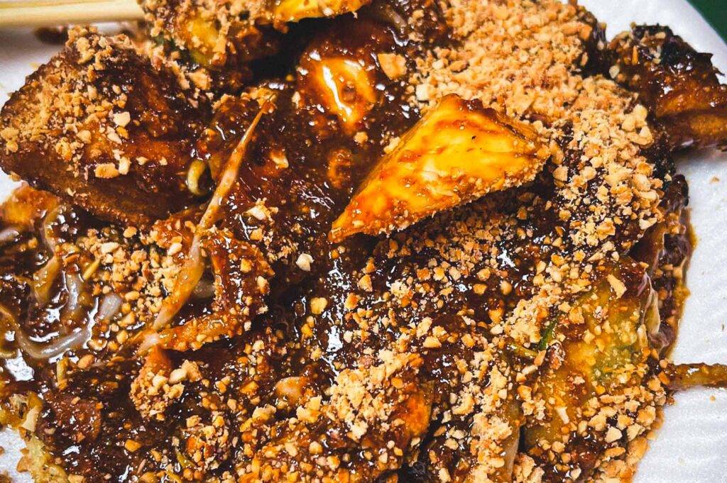 Close-up shot of rojak in rich peanut sauce.