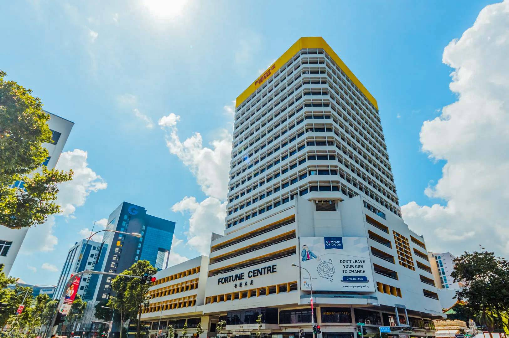 High‑rise Fortune Centre building photographed from street level on a sunny day, surrounded by modern city structures.