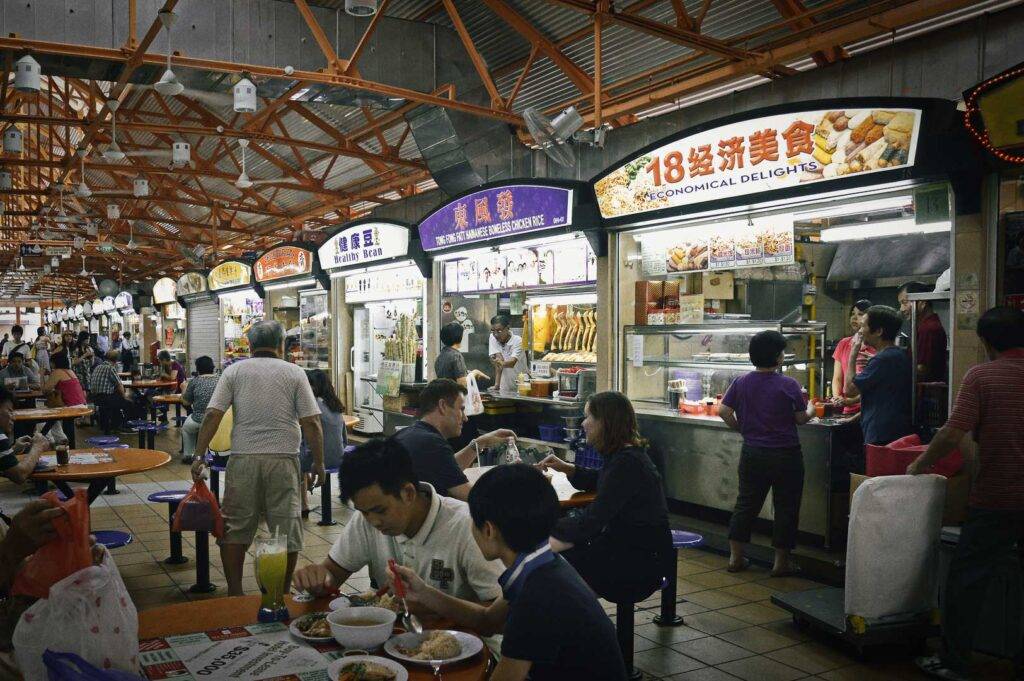 Bustling Singapore hawker center with food stalls.