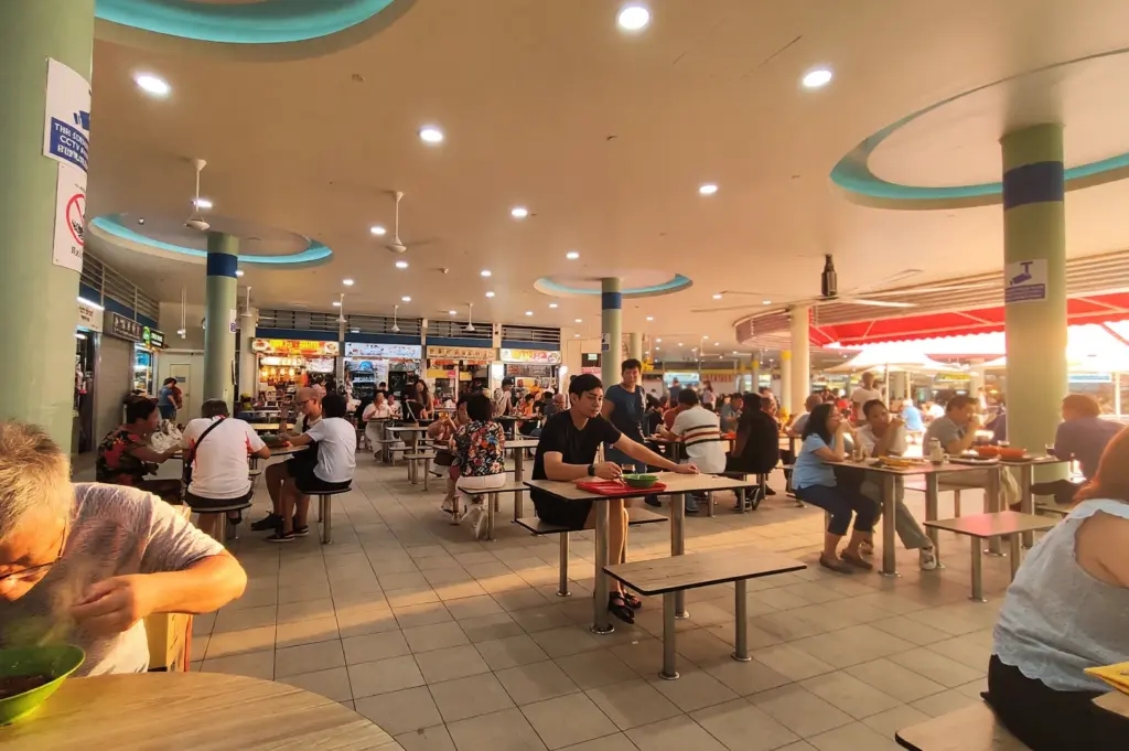 The interior of Tiong Bahru Market’s upper-floor hawker centre, showcasing an open-plan layout that encourages natural light and seamless movement between food stalls and dining tables.