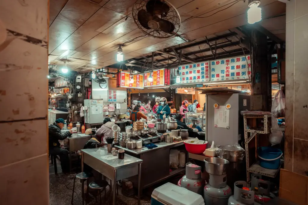 Behind-the-scenes look at a busy Asian hawker centre stall, where staff follow silent, rhythmic preparation routines to set up cooking stations before the arrival of dinner queues.