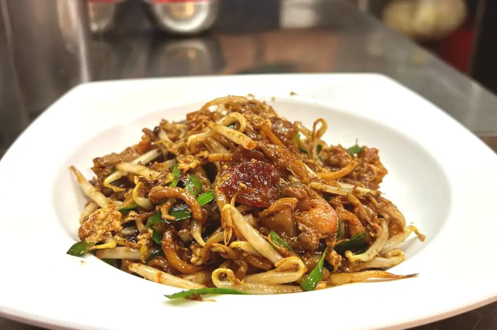 Char kway teow on a plate, still warm from the wok.